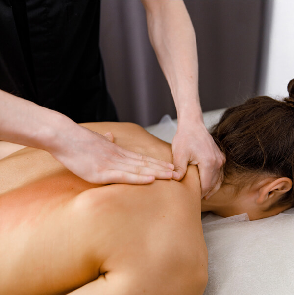 Un massothérapeute professionnel effectuant un massage du dos sur un client dans un spa, soulignant l'importance de la régularité.